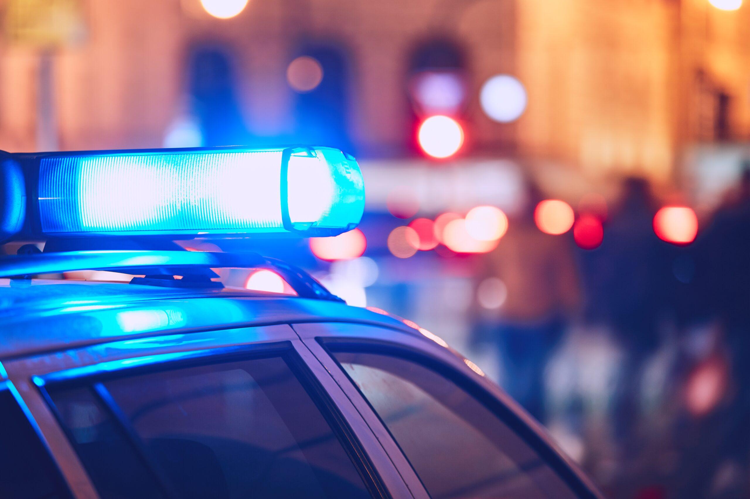 Image of Police care blue flashers on at night
