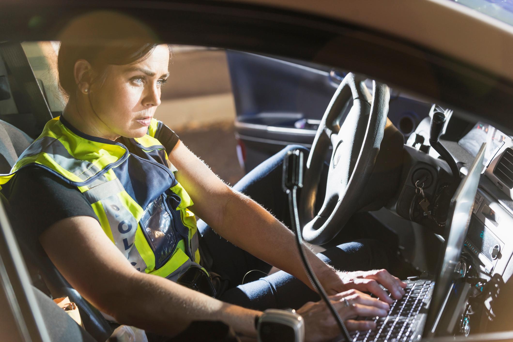 A police officer using in-vehicle technology.
