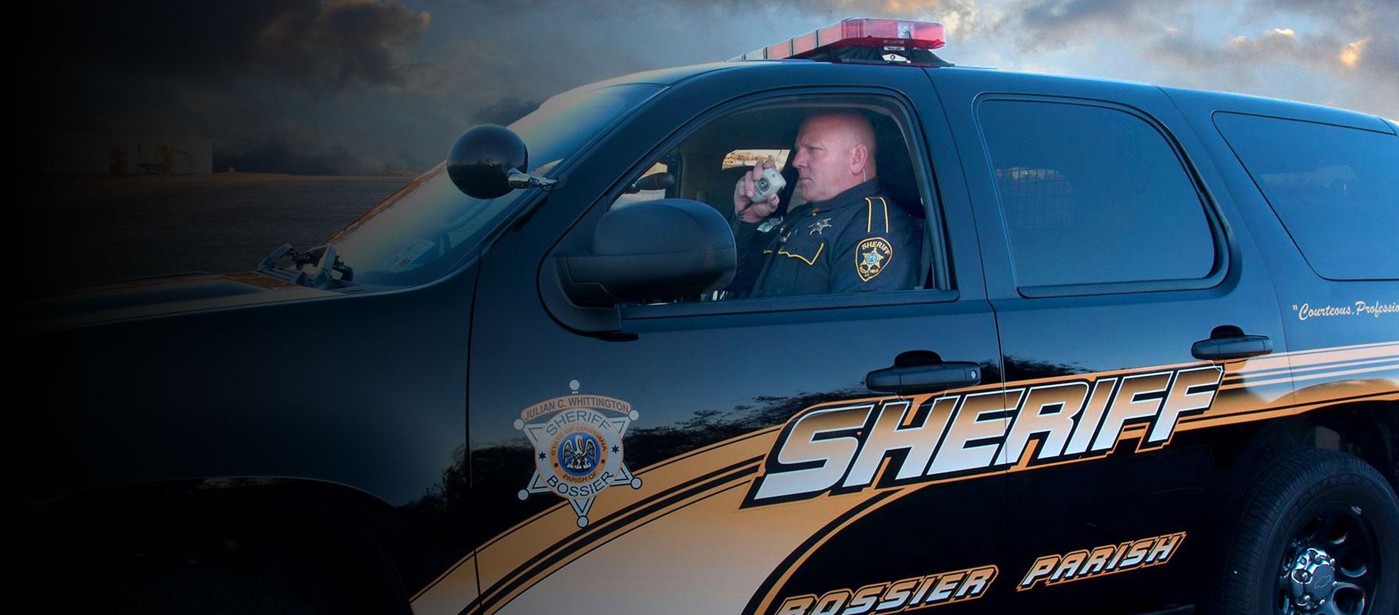 Mobile-optimized background image of a Bossier Parish Sheriffs vehicle.