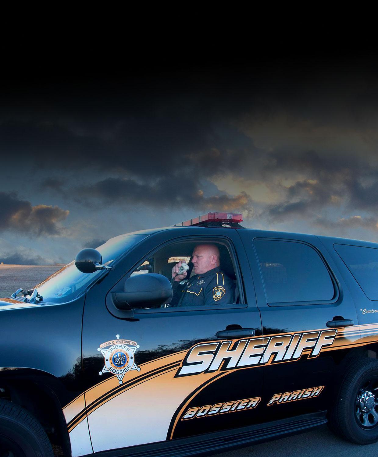 Mobile-optimized background image of a Bossier Parish Sheriffs vehicle.