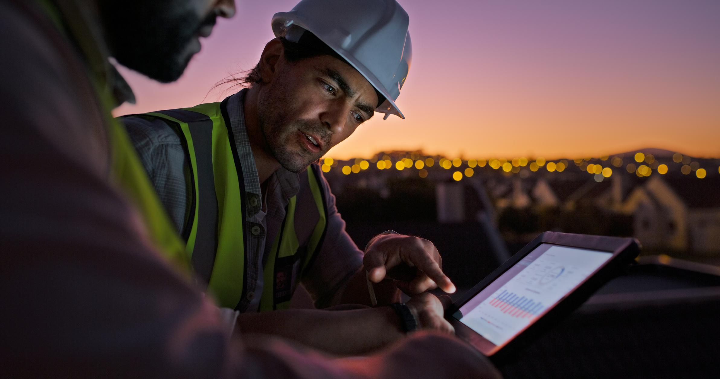 Construction workers on tablet planning, development or expansion.