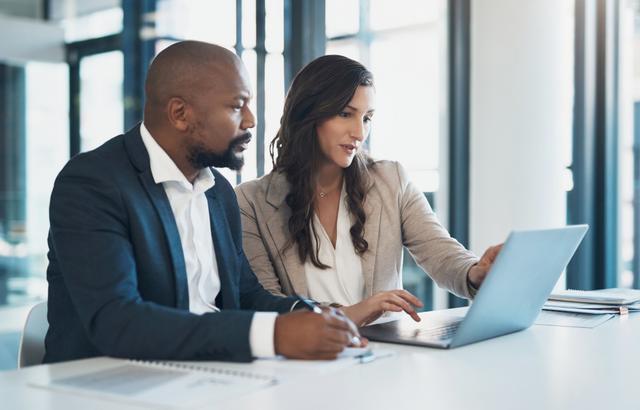 two people in a meeting looking at a laptop