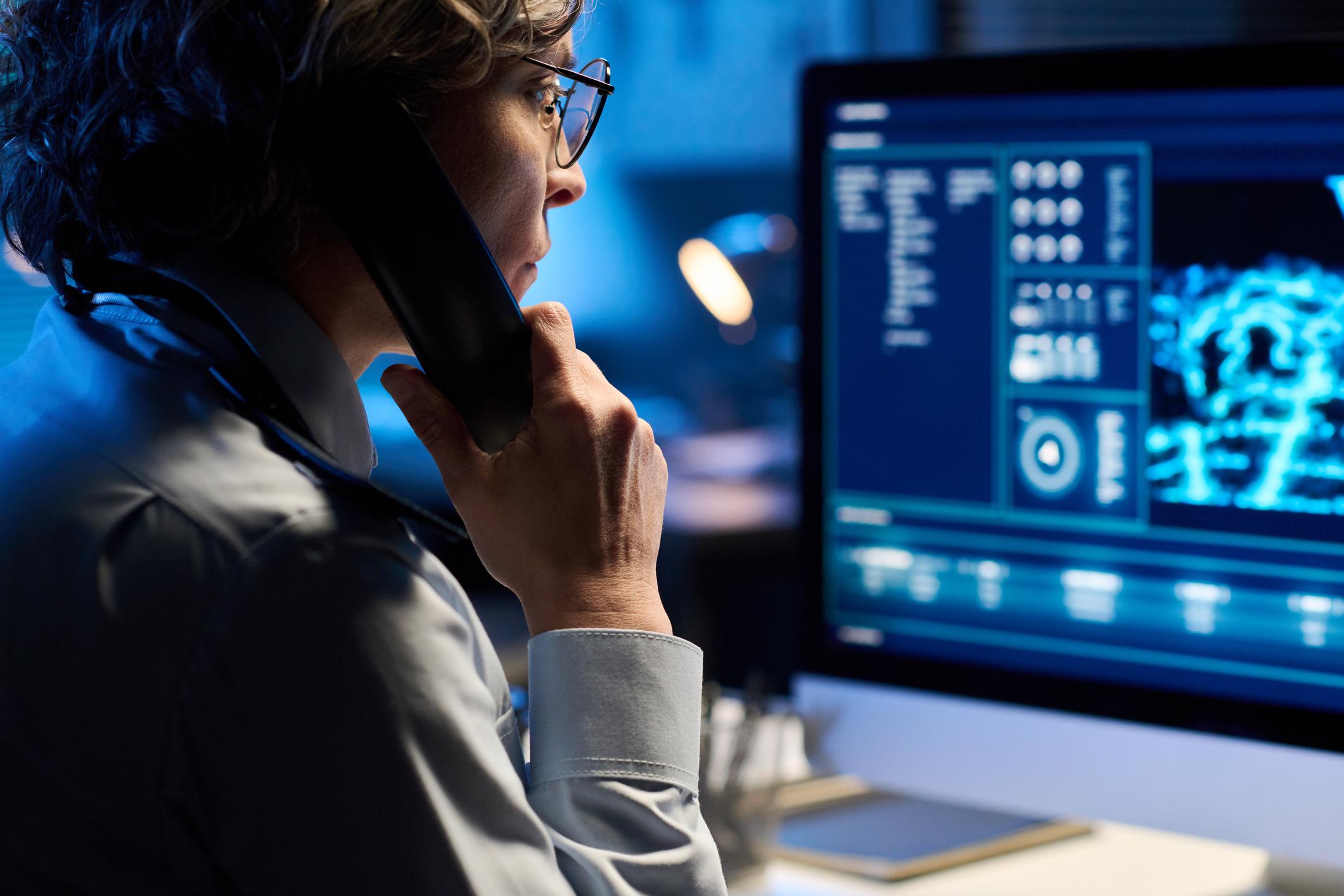 911 dispatcher taking a call looking at computer screen