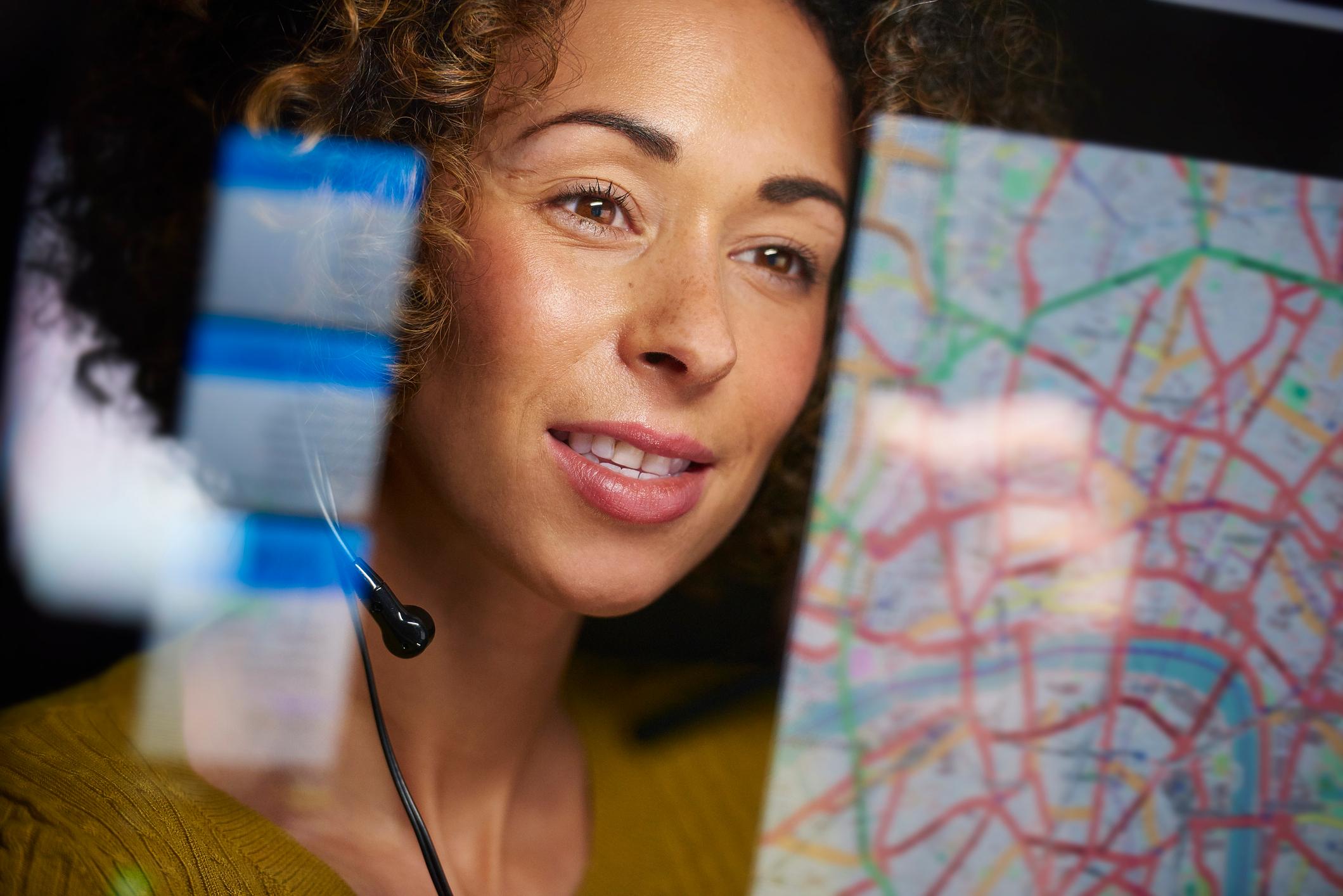 911 dispatcher with headset looking at a digital map
