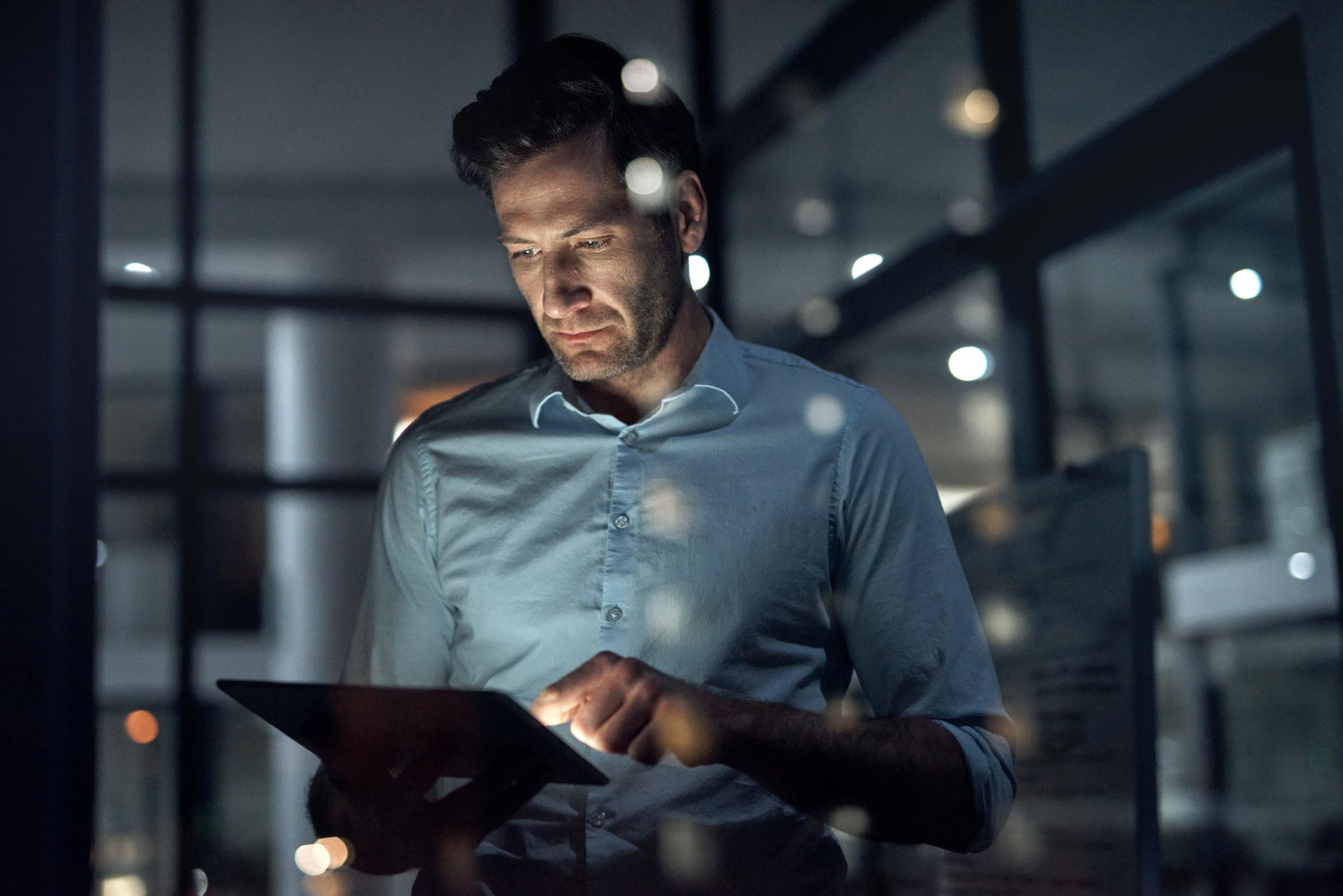 Business man, working and tablet of a employee doing digital, web and internet strategy planning. Corporate businessman and tech worker in the dark using technology to work on online and IT analytics