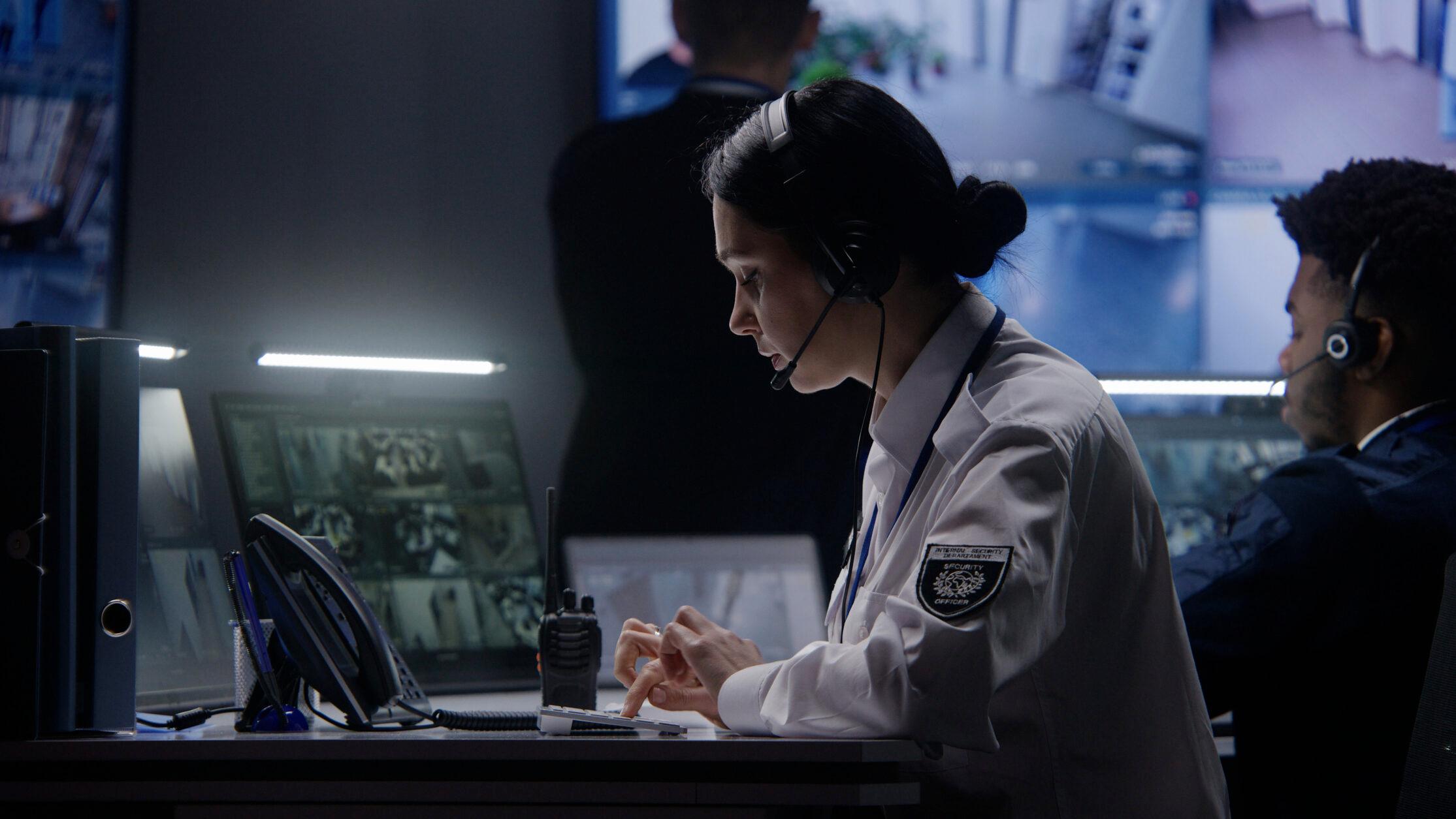 Female officer works on computer in police monitoring center