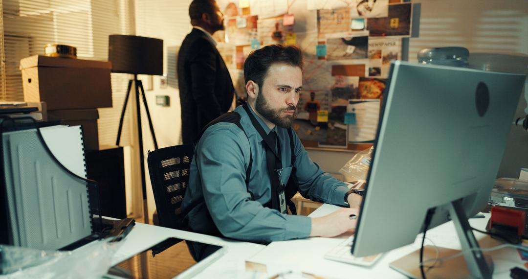 Male detective reviewing case file on computer