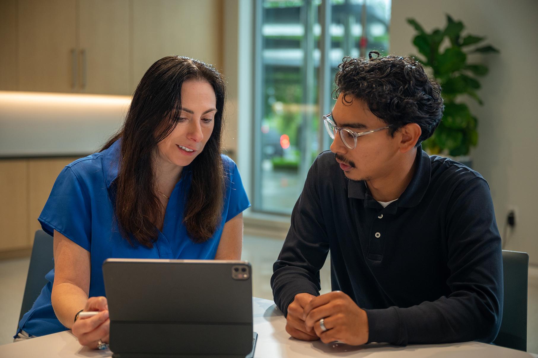 An image of a woman and man looking at a computer together.
