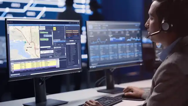Screengrab of dispatcher answering a call and looking at two monitors