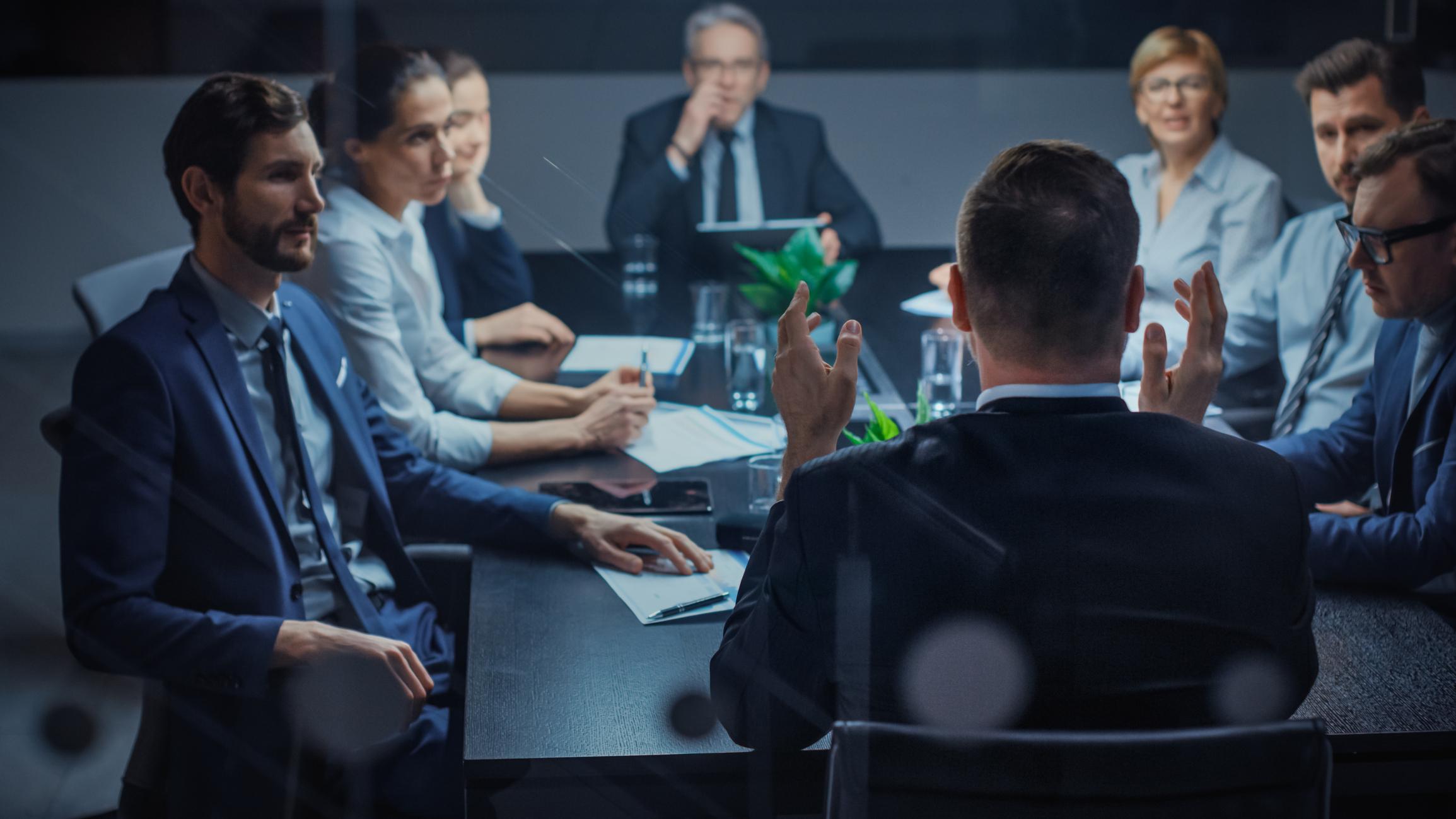 Professionals sitting around executive table meeting at an office